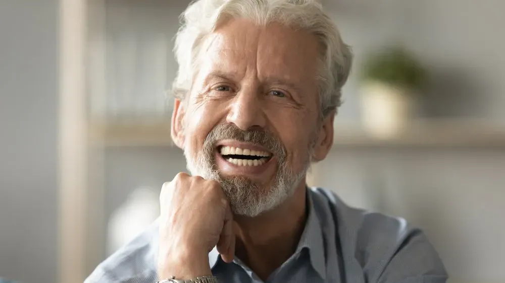 Happy Old Man smiling showing dentures