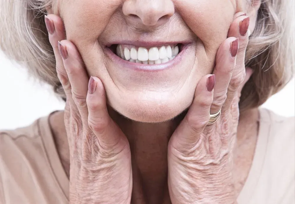 Happy Old Woman smiling showing clean dentures