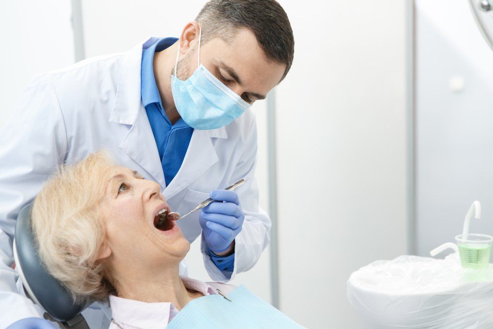 dentist with patient installing dentures
