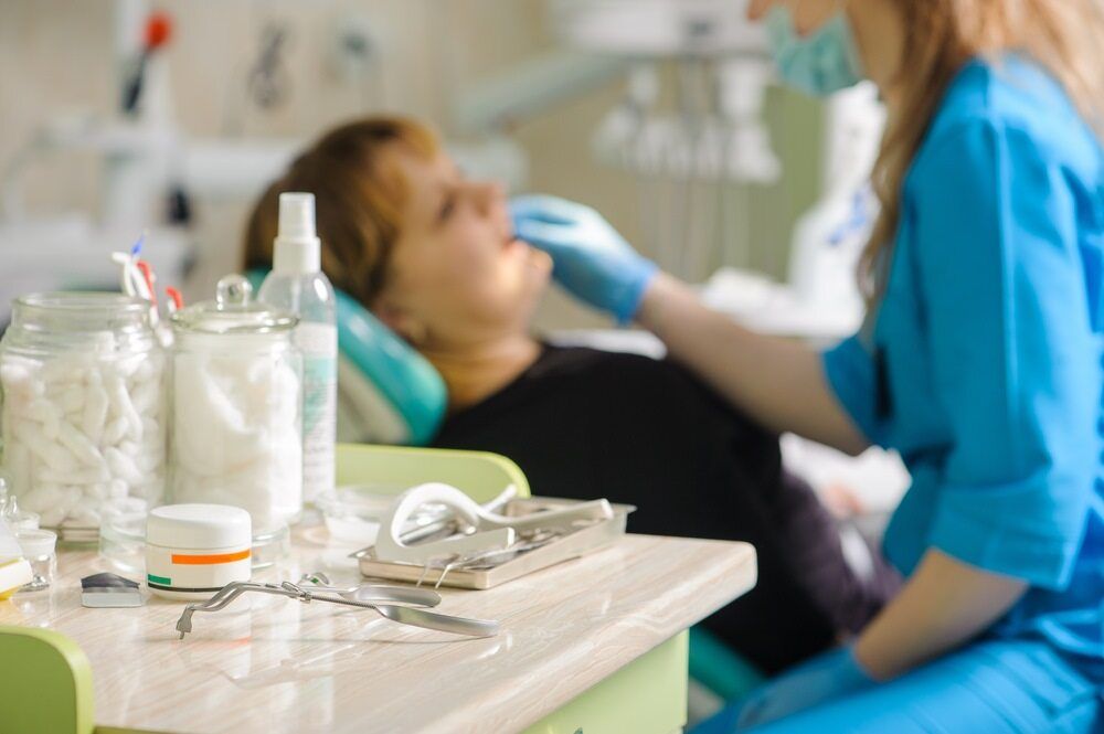 Dentist Examining Patient in a Dental Office — The Denture Care Group Sunshine Coast in Caloundra, QLD