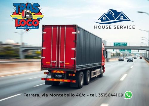 Un braccio di un escavatore che scarica rottami in un cassonetto blu, all'interno di un magazzino.