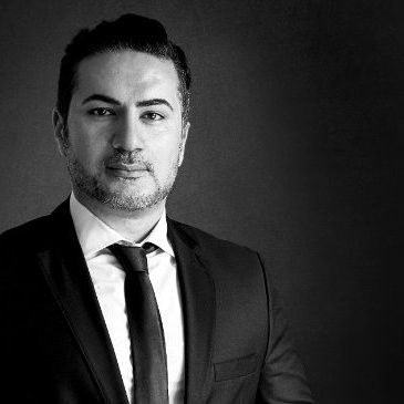 Ein Schwarzweißfoto eines Mannes in Anzug und Krawatte.