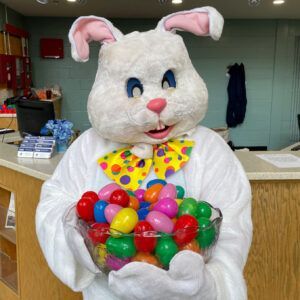 Easter Bunny holding a bowl of colorful plastic eggs.