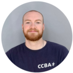 Man with a ginger beard wearing a navy blue t-shirt with a 