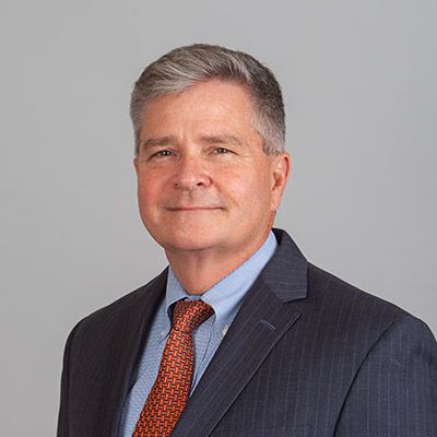 A man in a suit and tie is smiling for the camera.