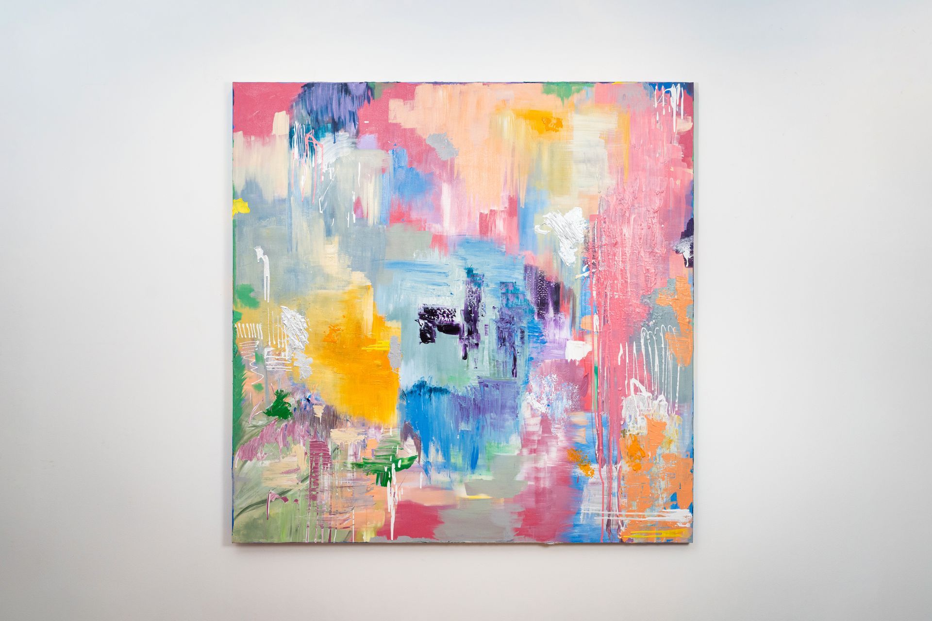 A colorful painting is hanging on a white wall.