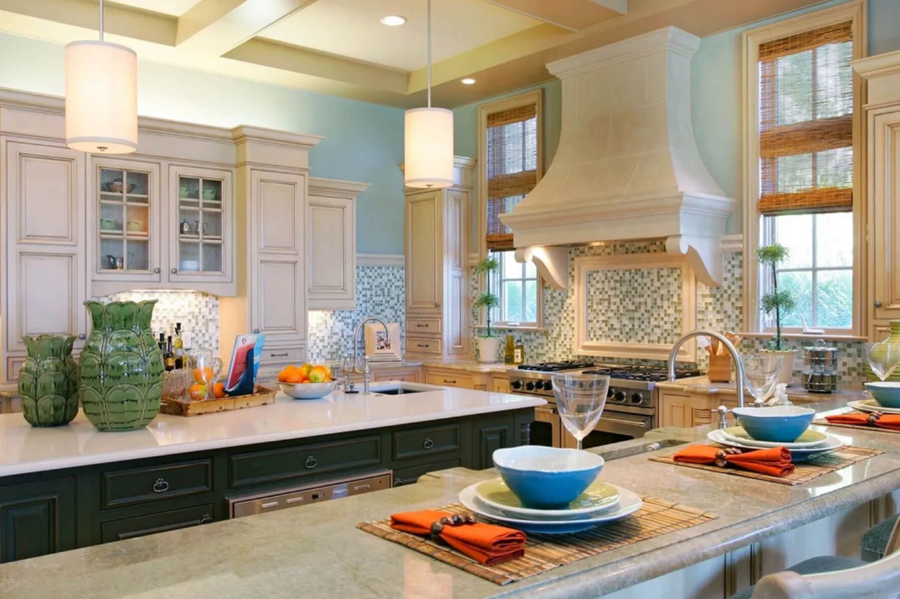 Coastal kitchen with white cabinets, blue walls, dark green island, and dining area.
