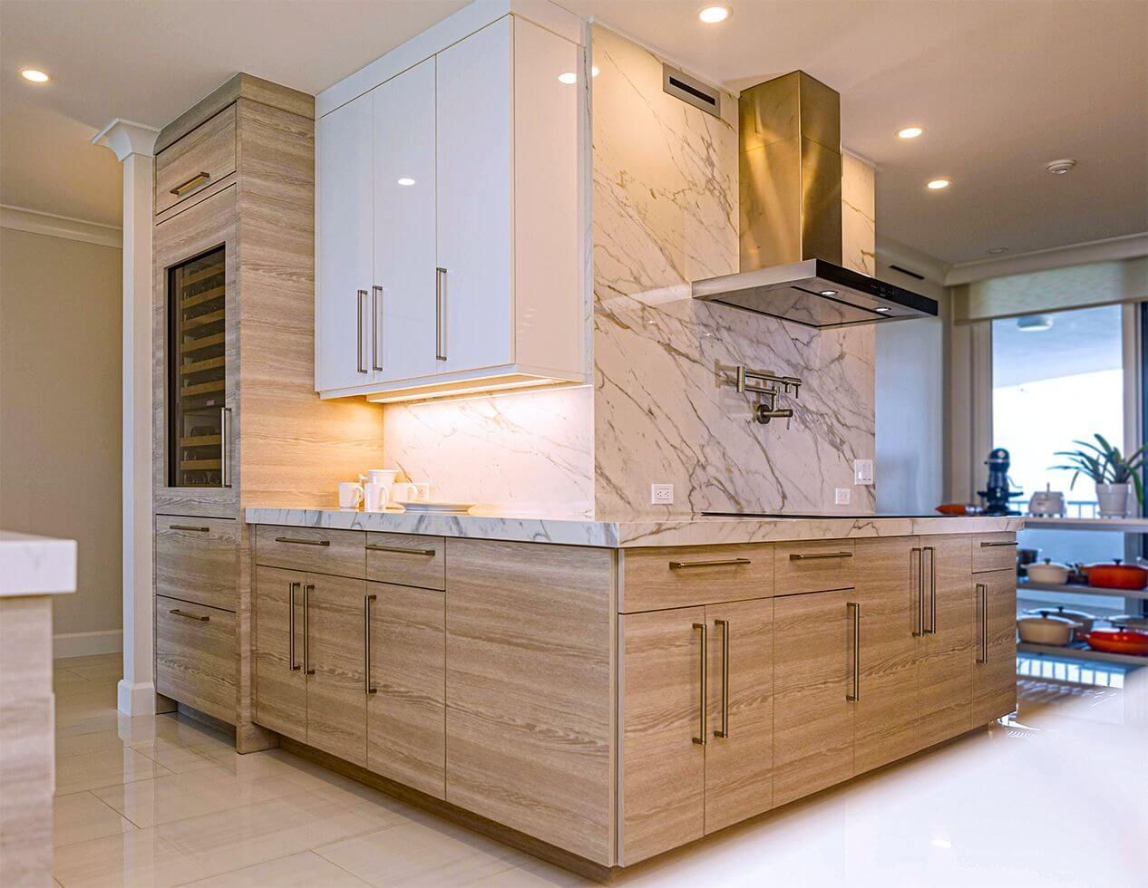 Modern kitchen with marble and light wood cabinetry, stainless steel range hood, and wine cooler.