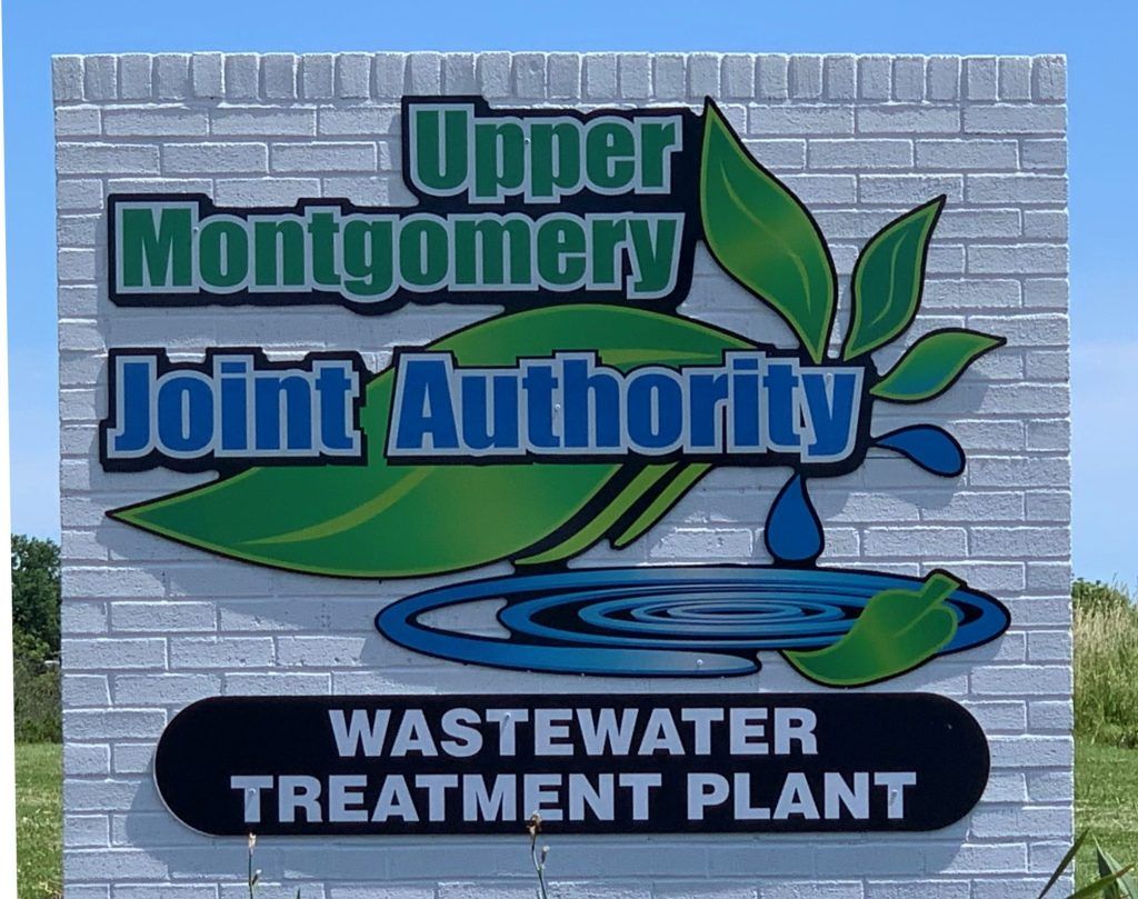 Sign for Upper Montgomery Joint Authority Wastewater Treatment Plant. Features a water droplet, leaves, and text.