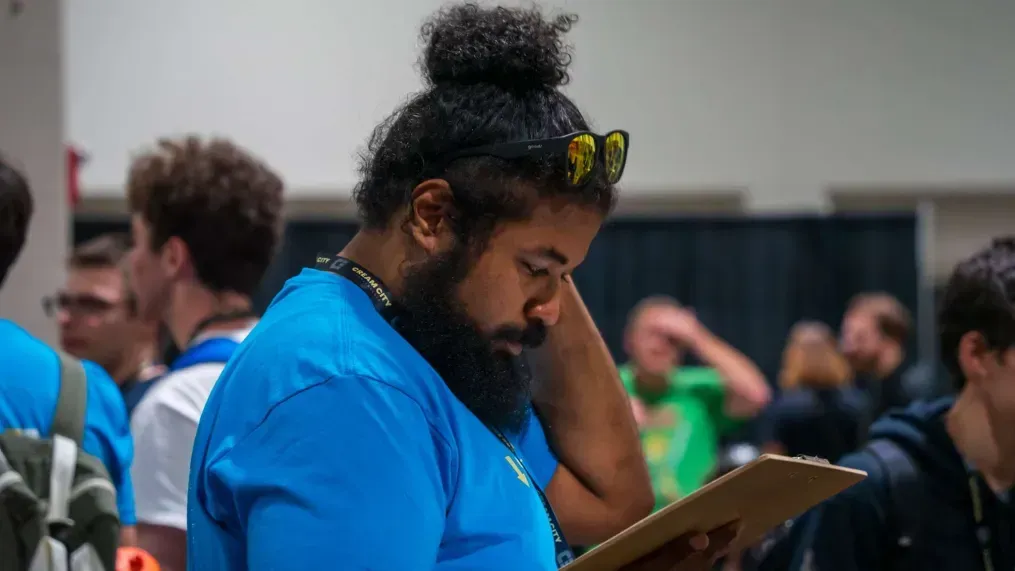 A man with a beard is looking at a clipboard.
