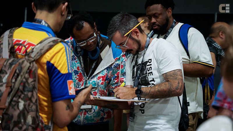 A man with a beard is looking at a clipboard.
