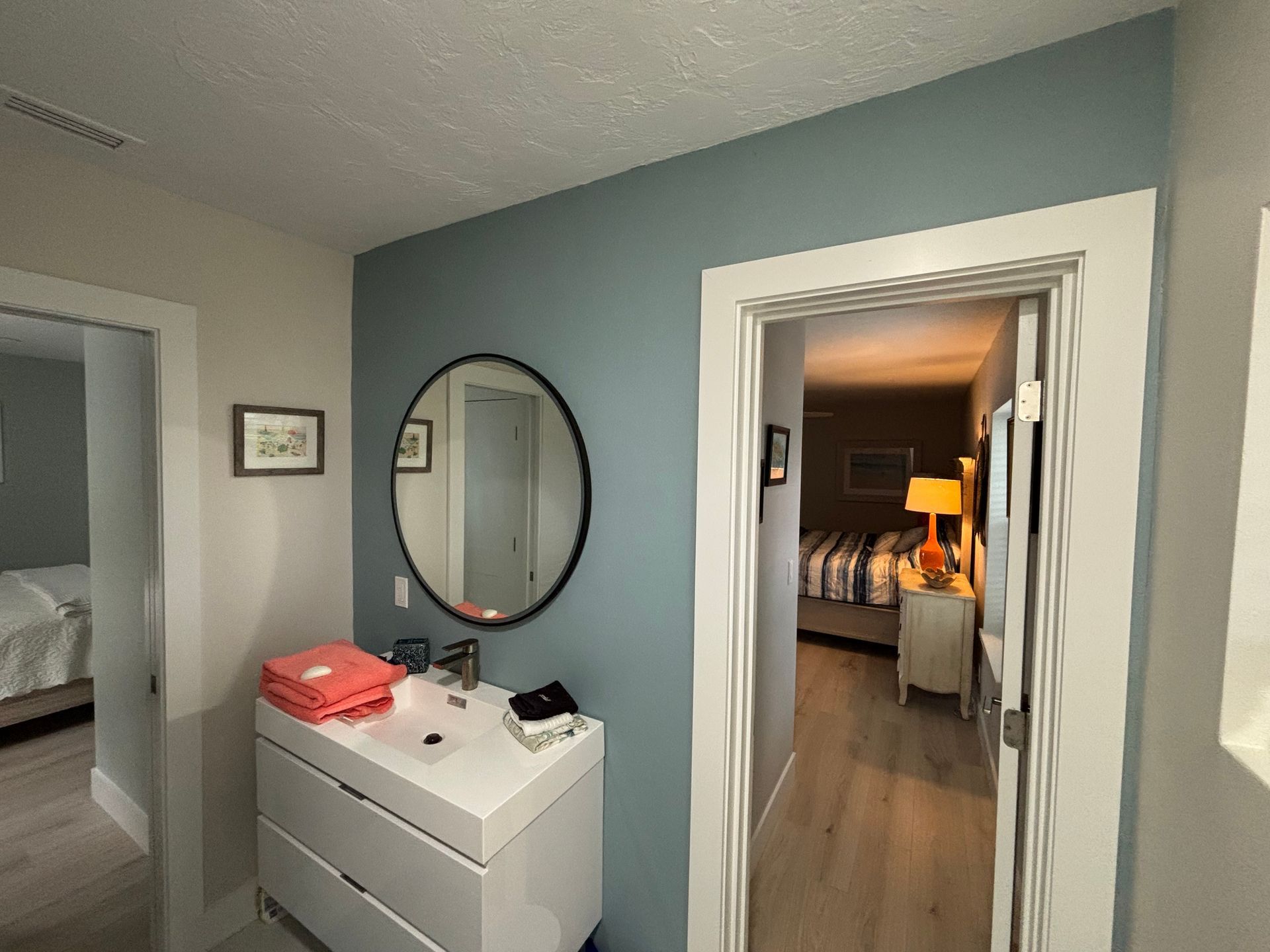 Room partially painted yellow, ladder, paint cans, and brush on wooden floor.