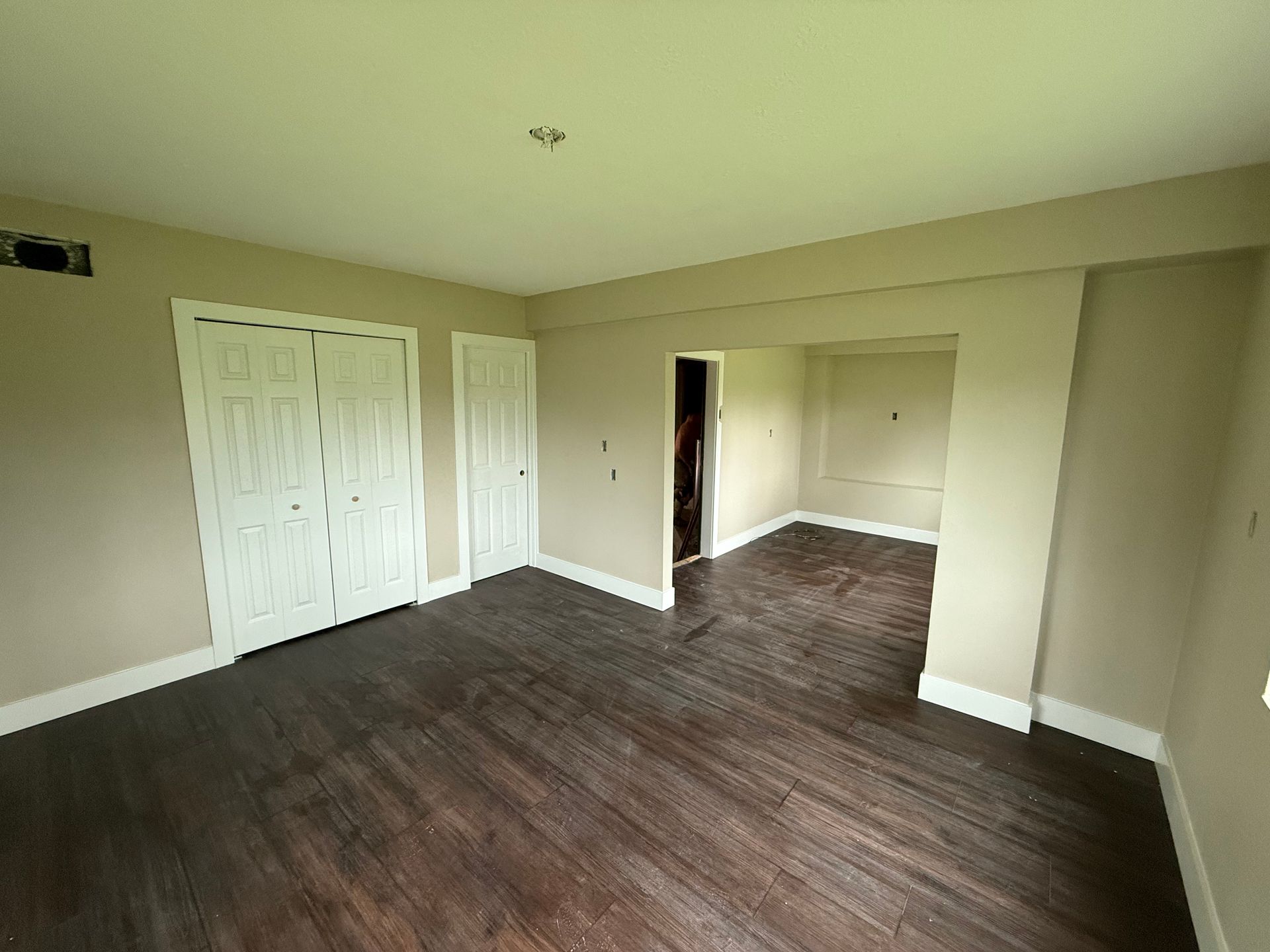 Wall being painted blue with paint roller and cans.