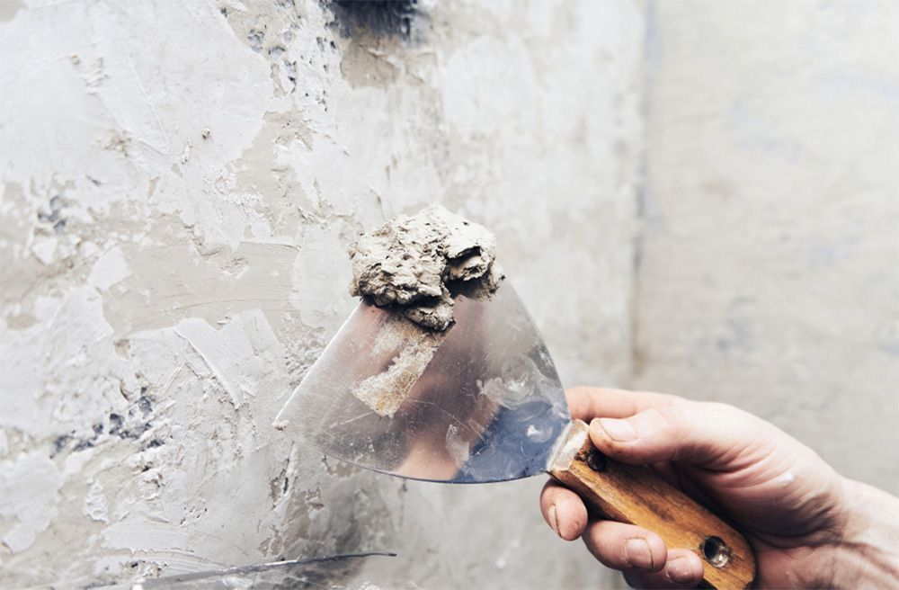Wooden bench on a deck, surrounded by wood and fence. Blue building and balcony in the background.