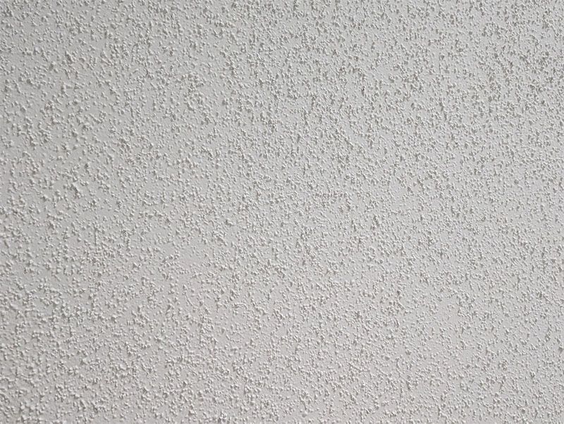 Painting a wooden railing with a blue paintbrush.