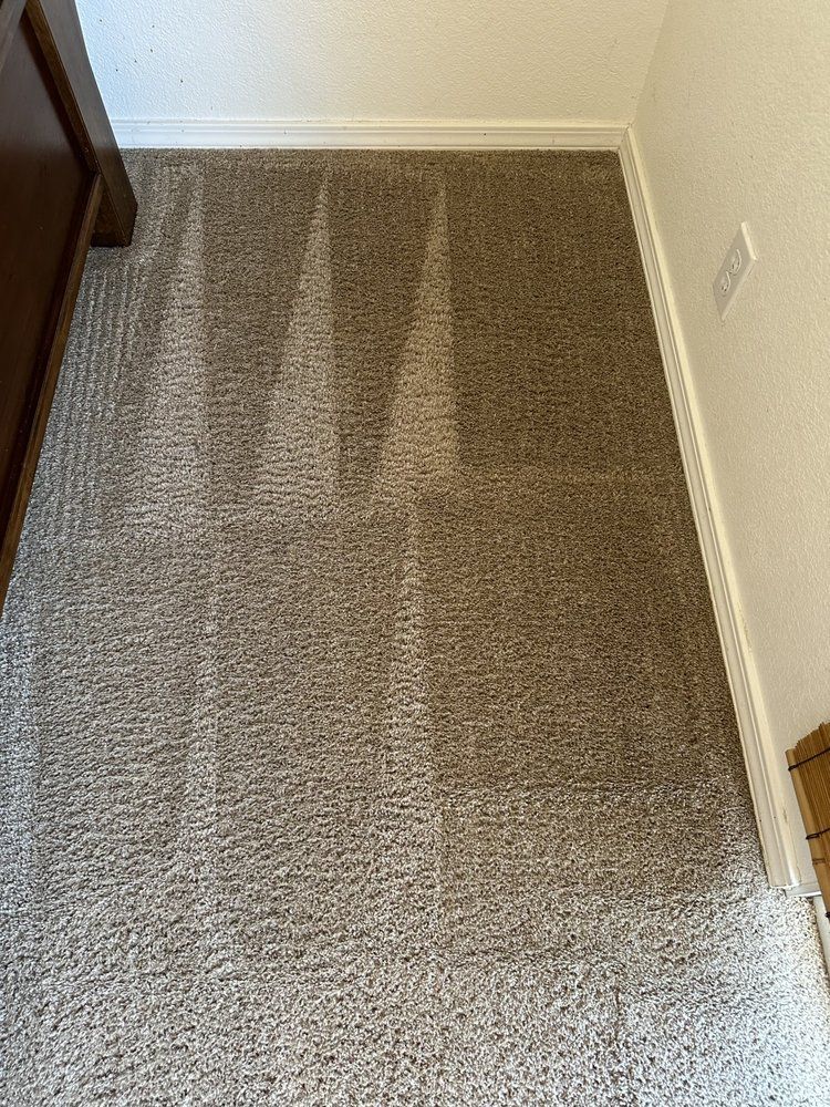 A room with a carpeted floor and a white wall.