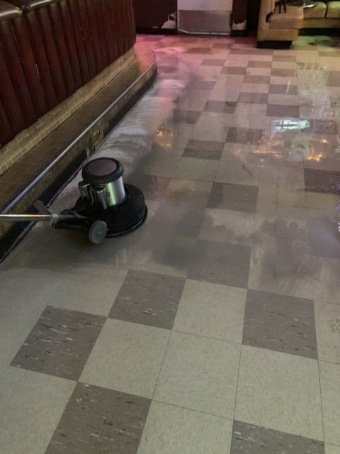 A machine is being used to clean a checkered floor