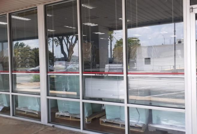 A construction worker is measuring a piece of wood in a kitchen.