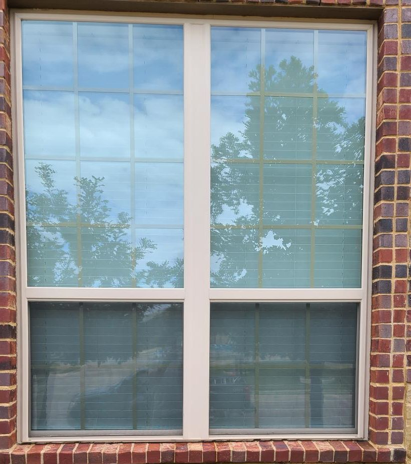 A construction worker is measuring a piece of wood in a kitchen.