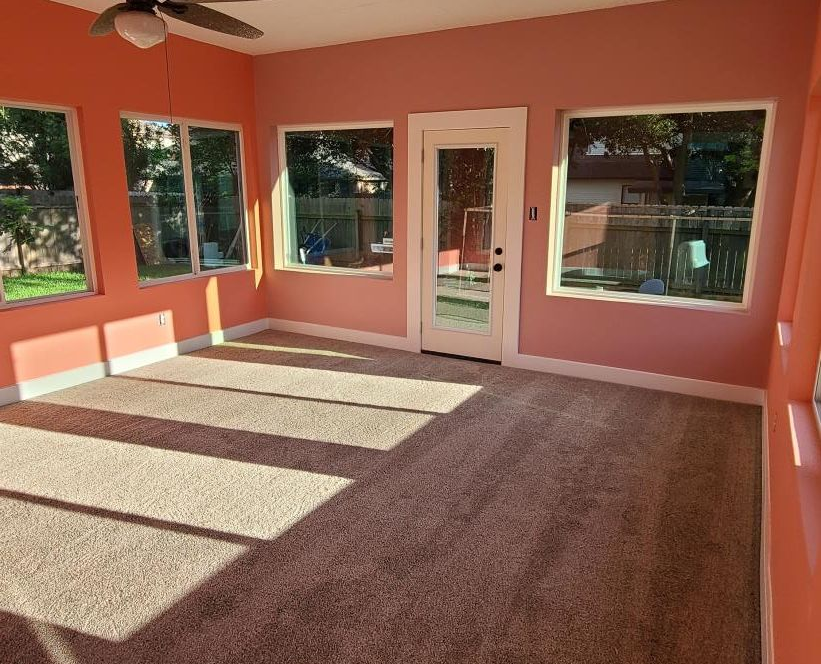 A construction worker is measuring a piece of wood in a kitchen.