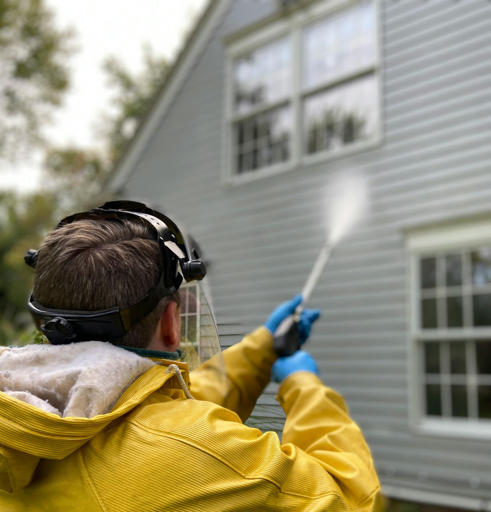 A construction worker is measuring a piece of wood in a kitchen.