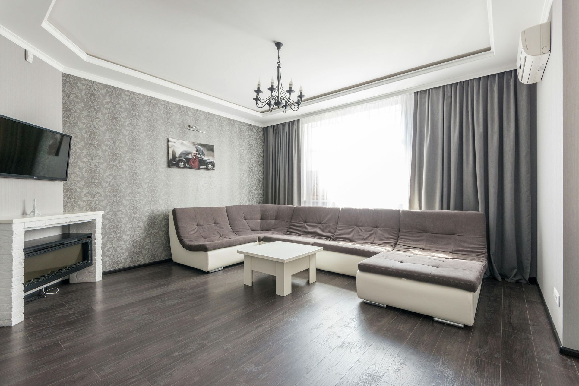 A construction worker is measuring a piece of wood in a kitchen.
