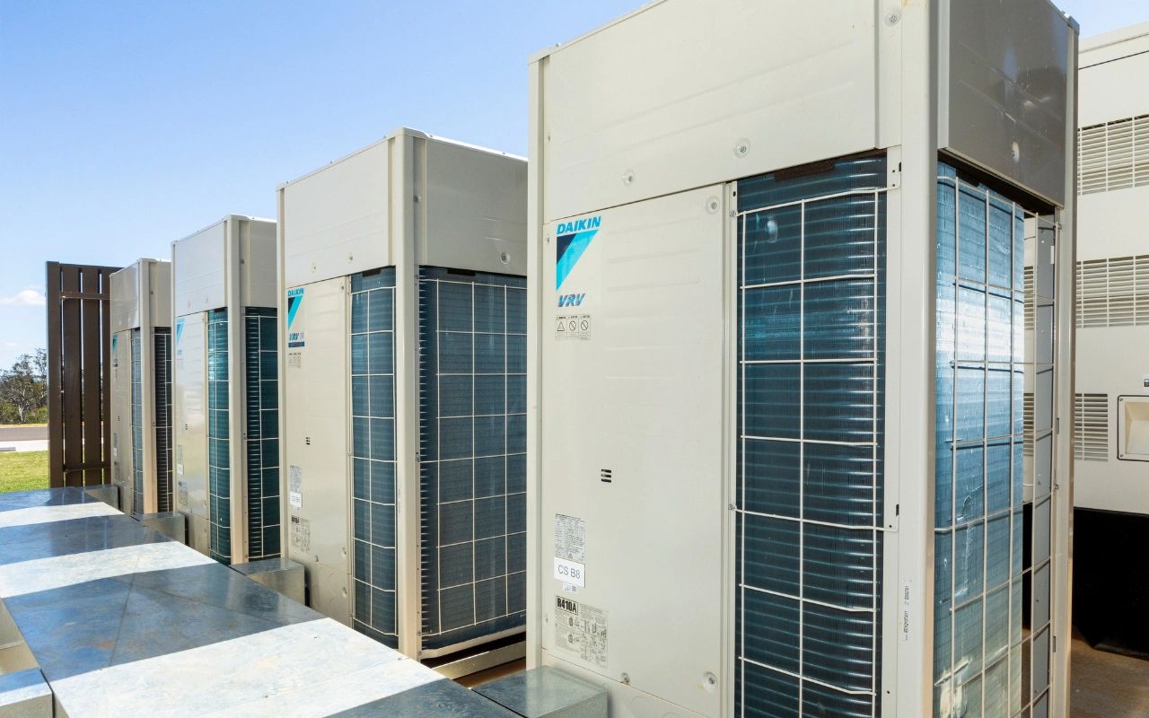 Row of Large Beige HVAC Units on Rooftop — Frostys Air-Conditioning Services in Cannonvale, QLD