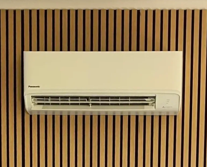 Wall-Mounted Air Conditioner Blowing Cool Air in A White Room — Frostys Air-Conditioning Services in Proserpine, QLD