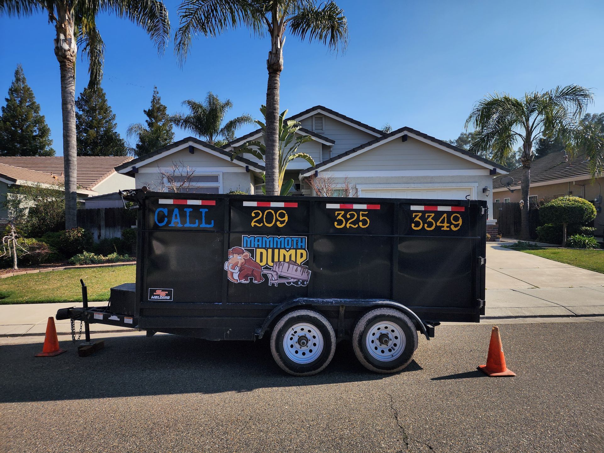 11 yard dumpster set up in front of a home with palm trees