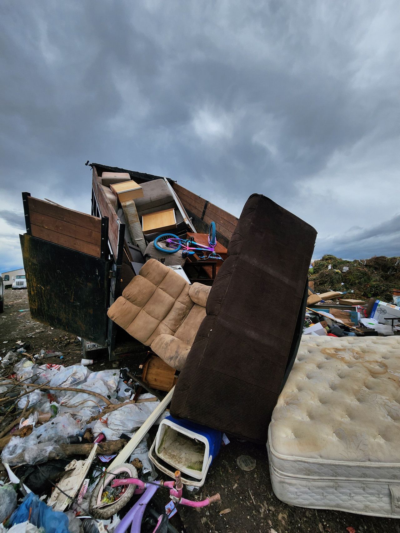 20-yard dumpster unloading old furniture at Merced landfill, as part of a responsible waste disposal process.