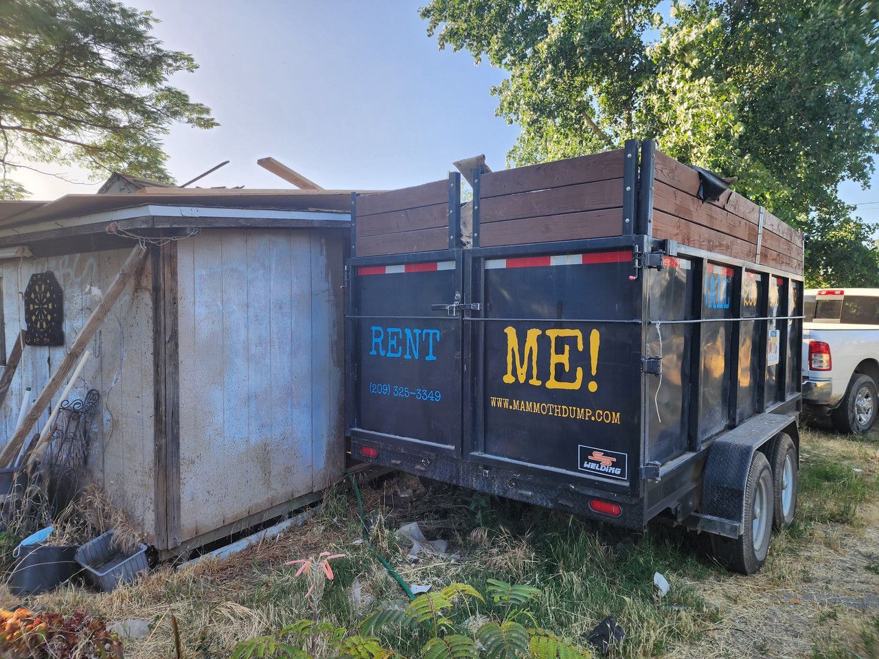 20-yard dumpster parked beside a home in Merced, CA, utilized for efficient disposal of materials from a roofing job.