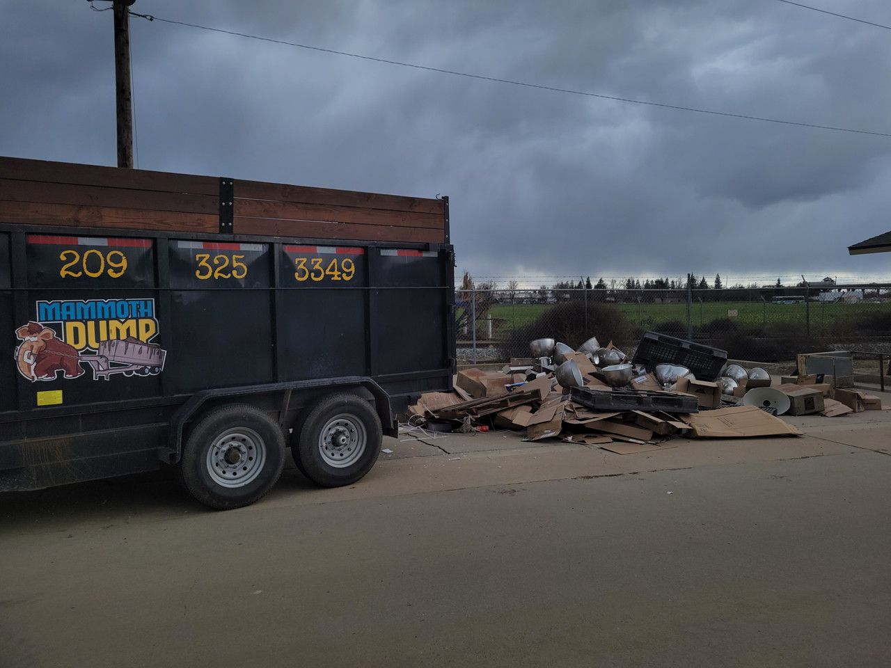 20 yard dumpster parked in front of a pile of commercial lighting waste and cardboard boxes