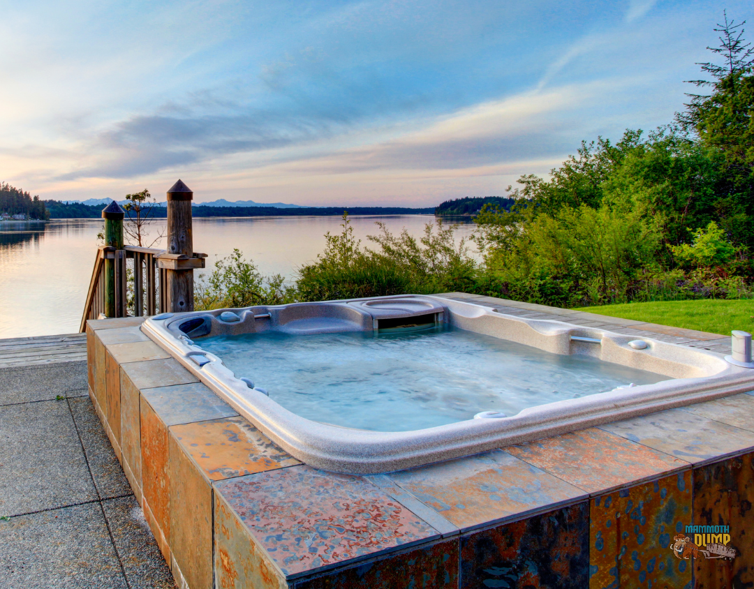 Luxurious hot tub adjacent to a stairway descending towards a serene lake, exemplifying the kind of hot tubs associated with removal costs.