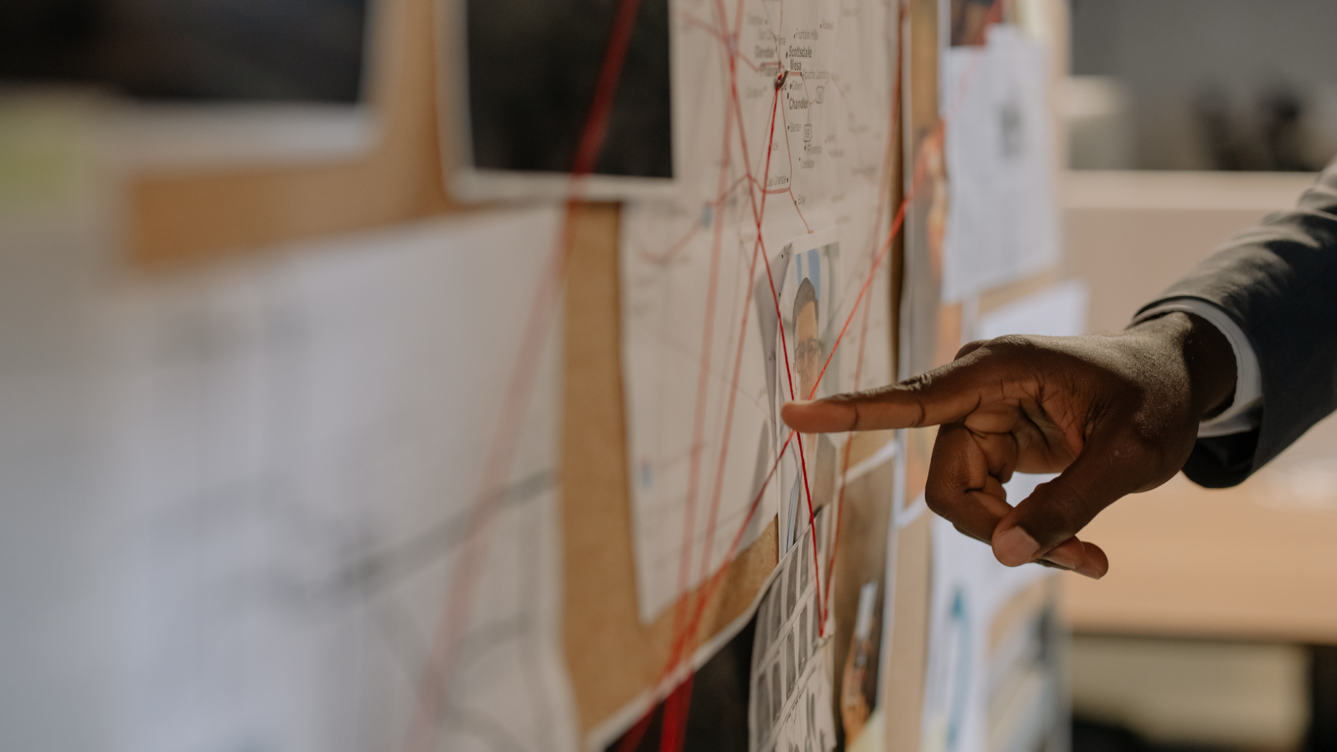 A magnifying glass over a coded document on a desk with an ashtray and envelope.