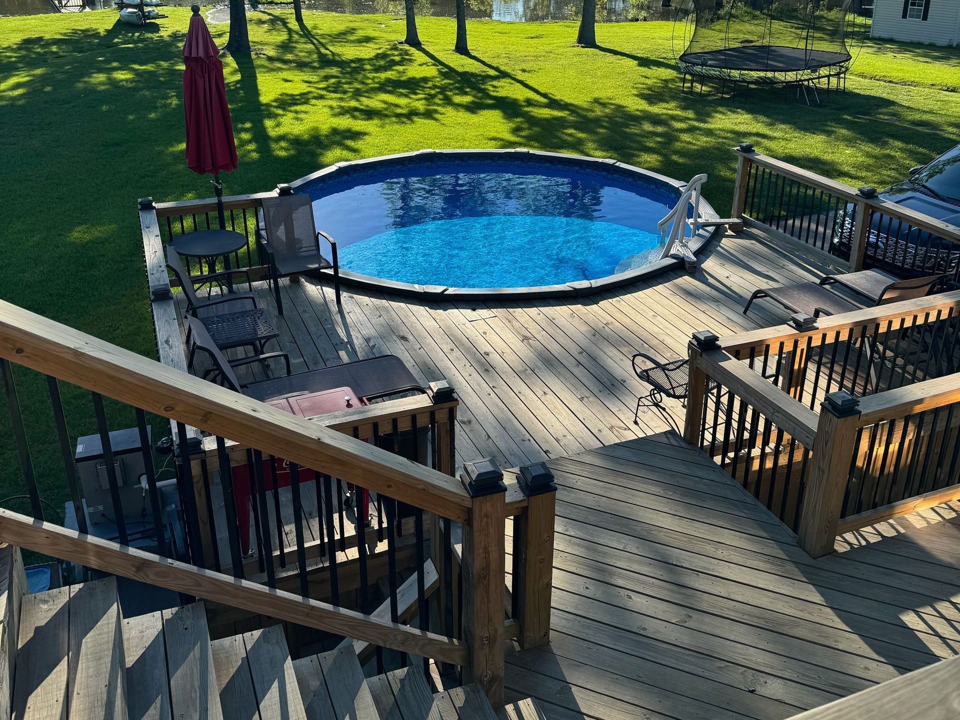 A swimming pool is sitting on top of a wooden deck.