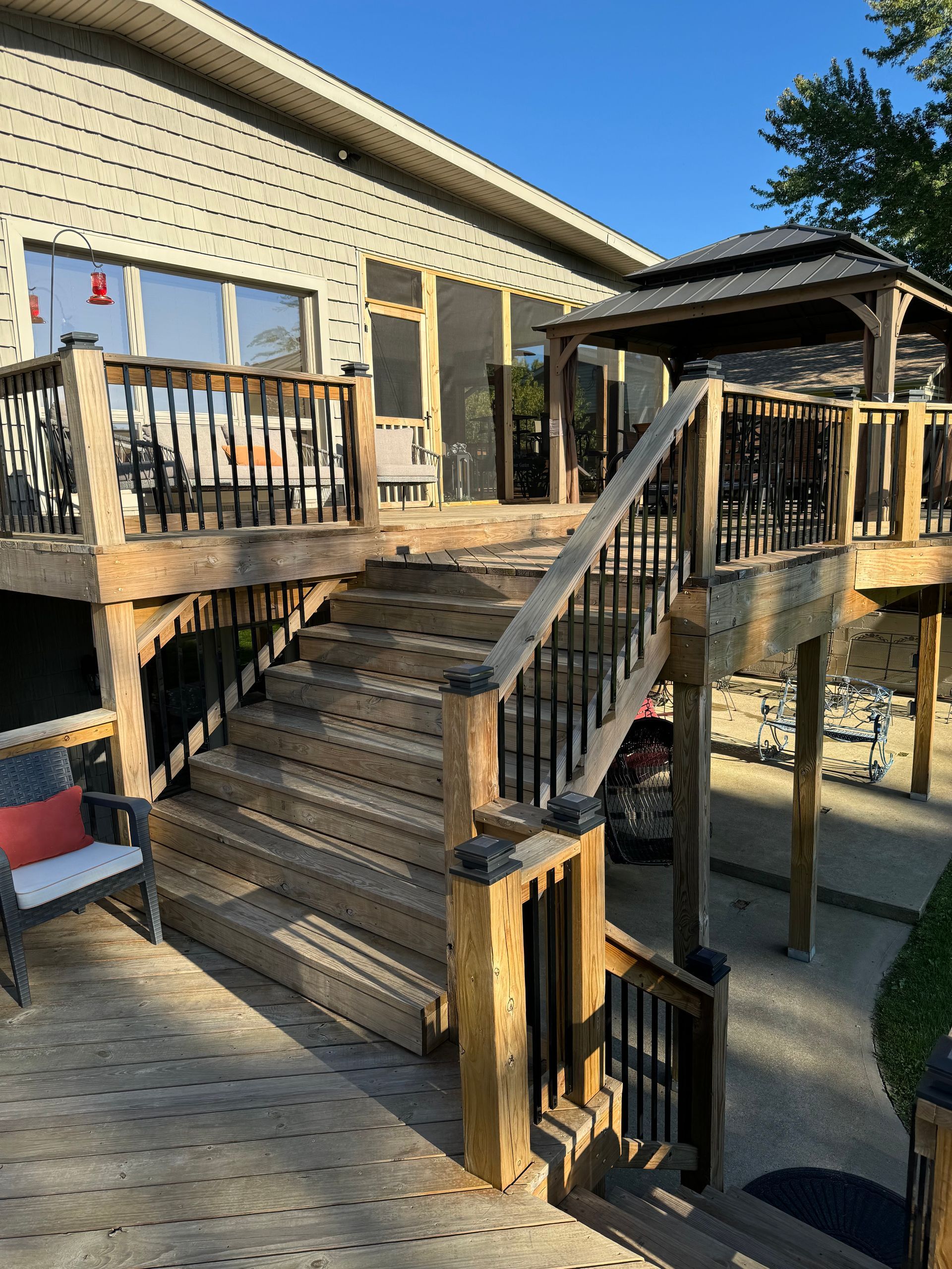 A wooden deck with stairs leading up to a house.