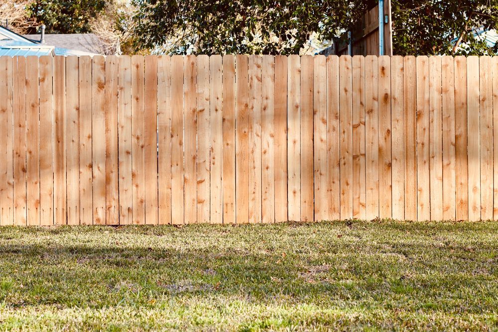 A wooden fence is sitting on top of a lush green lawn.