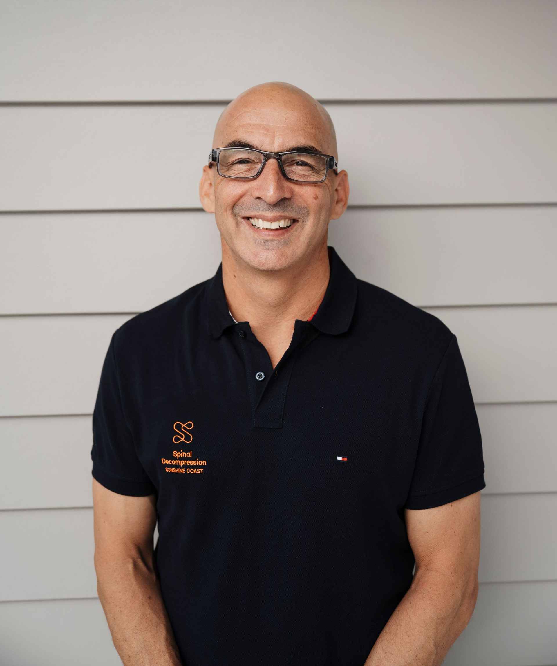 Man With Arms Crossed, Smiling in Front of a Chiropractic Office — Spinal Decompression Sunshine Coast In Mooloolaba, QLD
