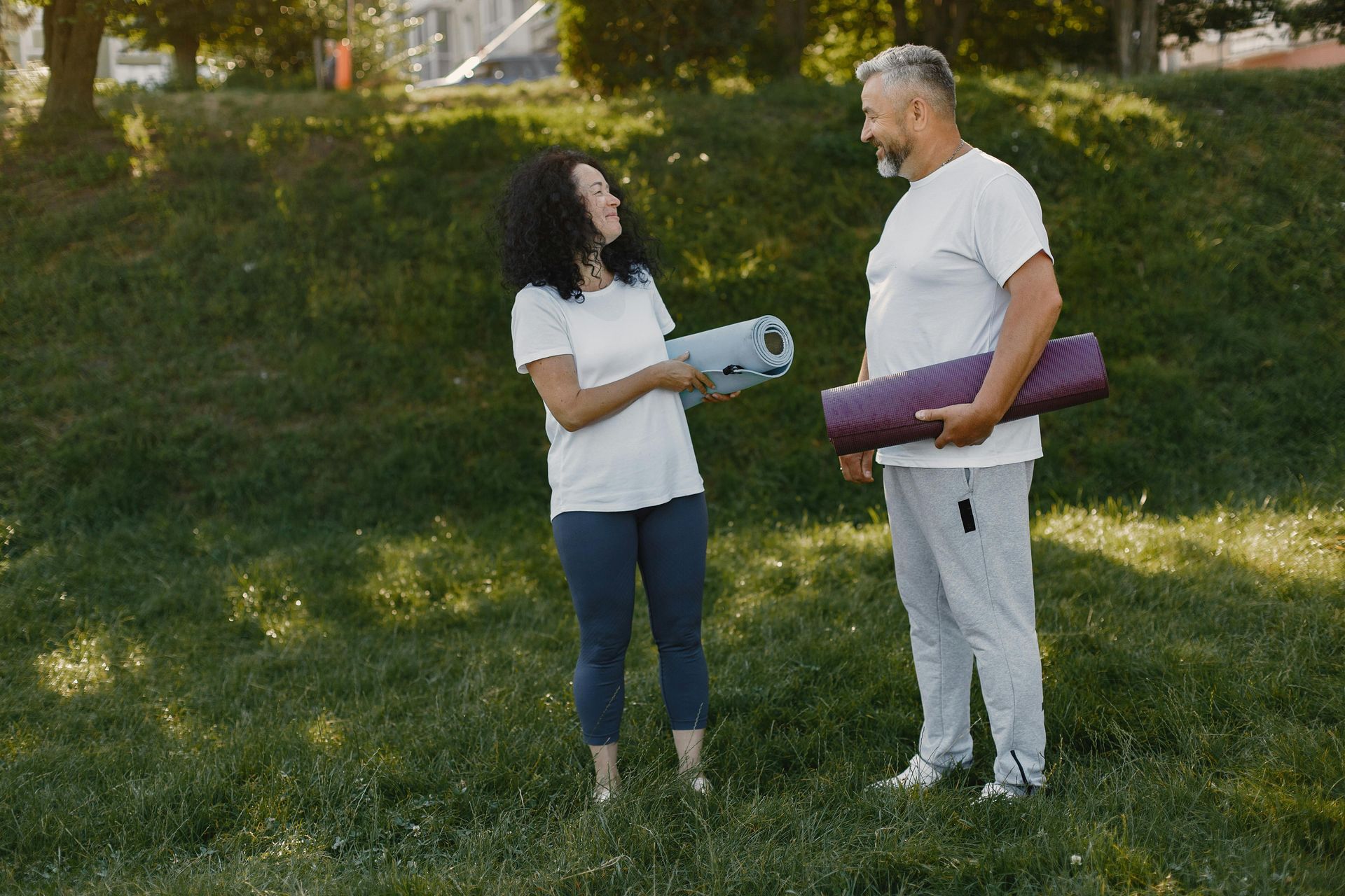 Woman and Man With Yoga Mats, Smiling — Spinal Decompression Sunshine Coast In Buderim, QLD
