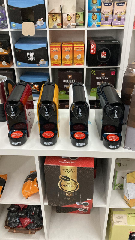 Su uno scaffale di un negozio sono disposte quattro macchine da caffè 