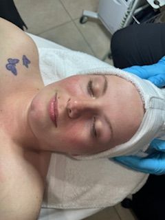 A woman is laying on a bed with a towel wrapped around her head.