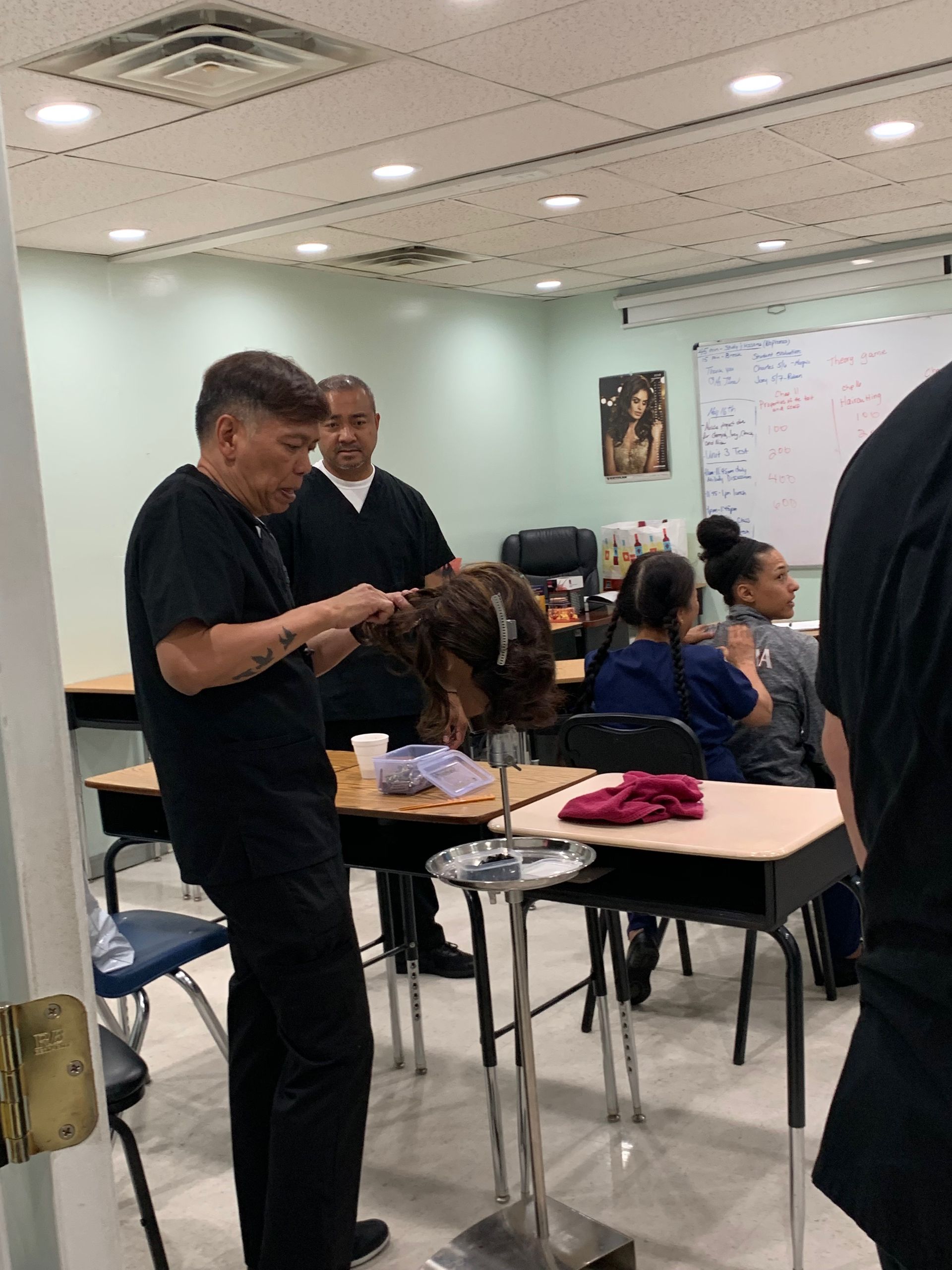 A group of people are sitting at desks in a classroom.