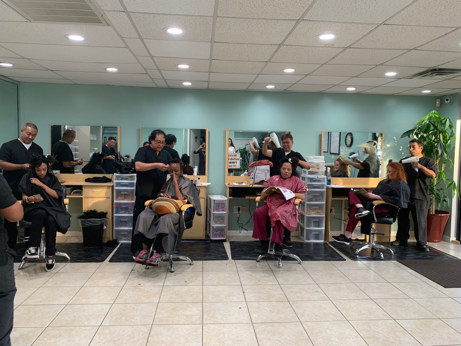 A group of people are getting their hair cut in a salon.