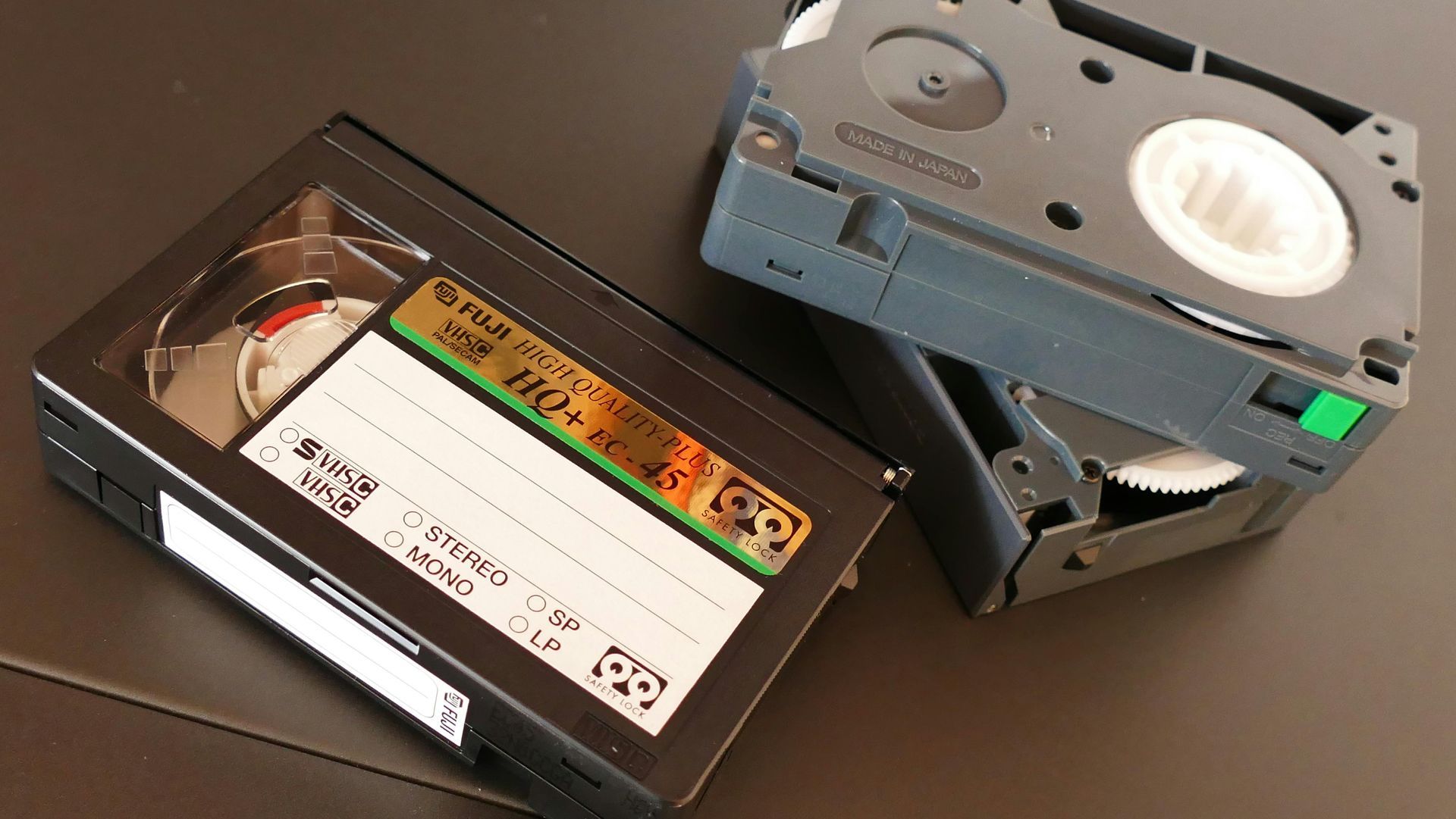 A stack of VHS and MiniDV tapes ready for digitization and editing