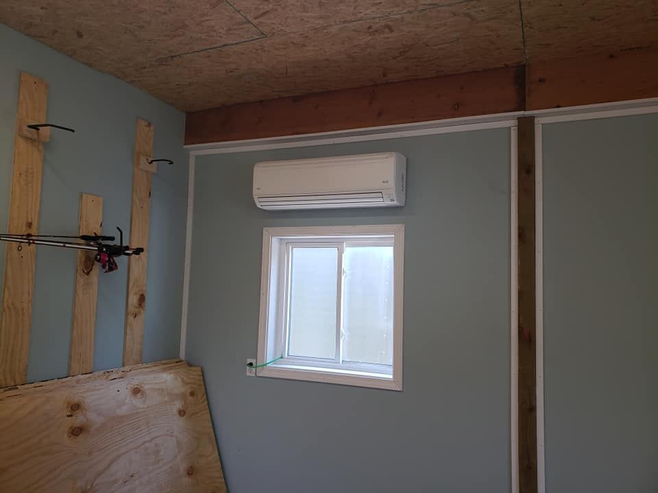 A room with a window and an air conditioner on the wall.