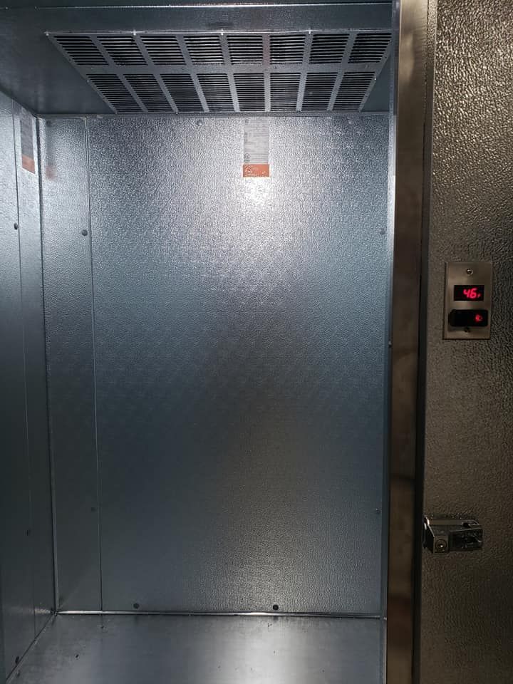 The inside of an elevator with a light on the ceiling.
