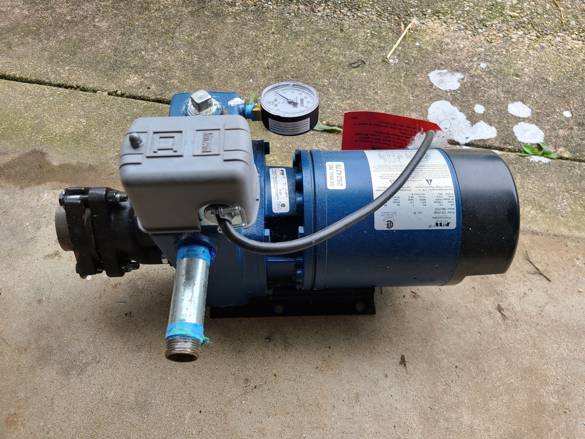 A blue water pump with a gauge attached to it