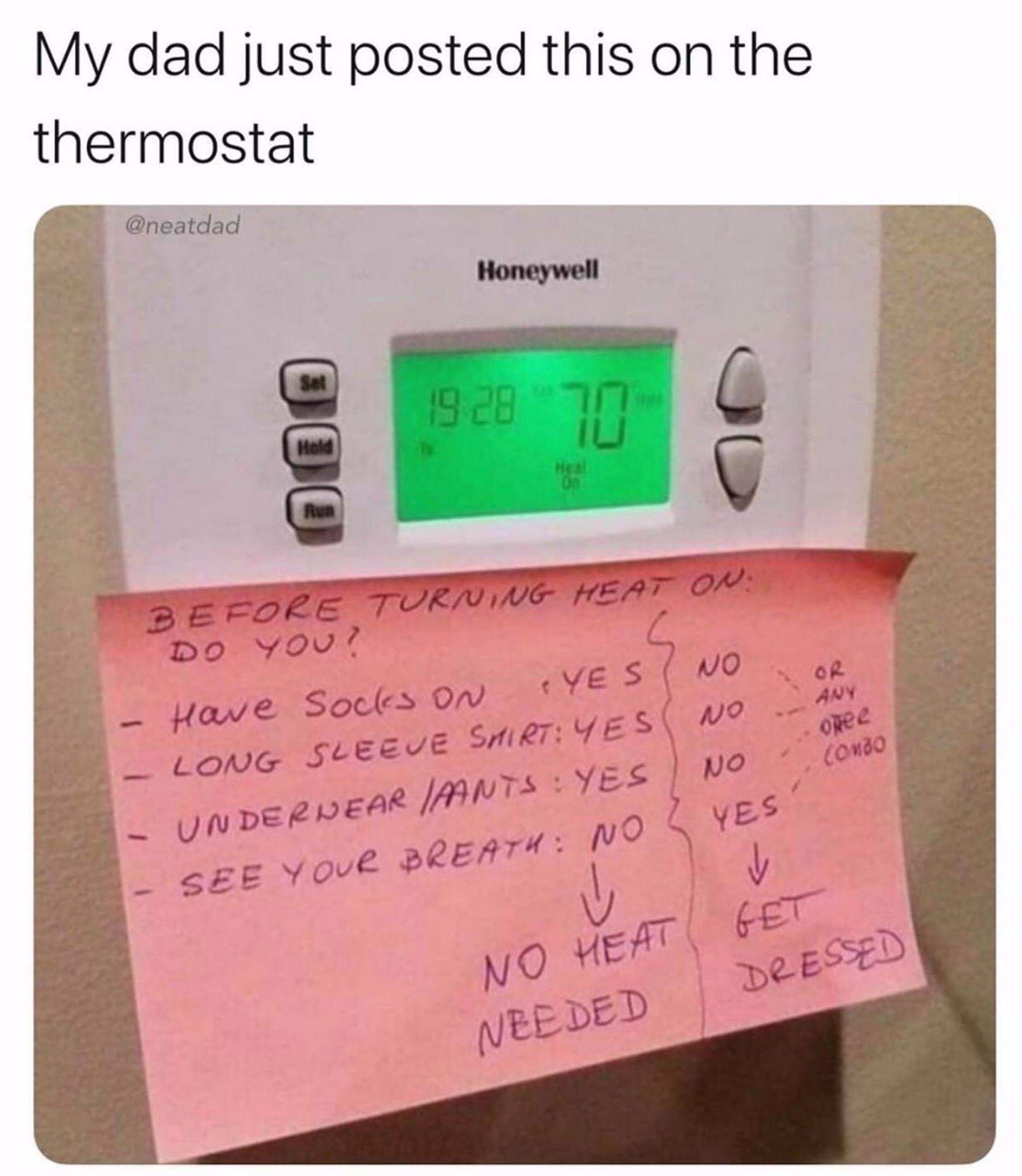 A thermostat with a note on it that says 
