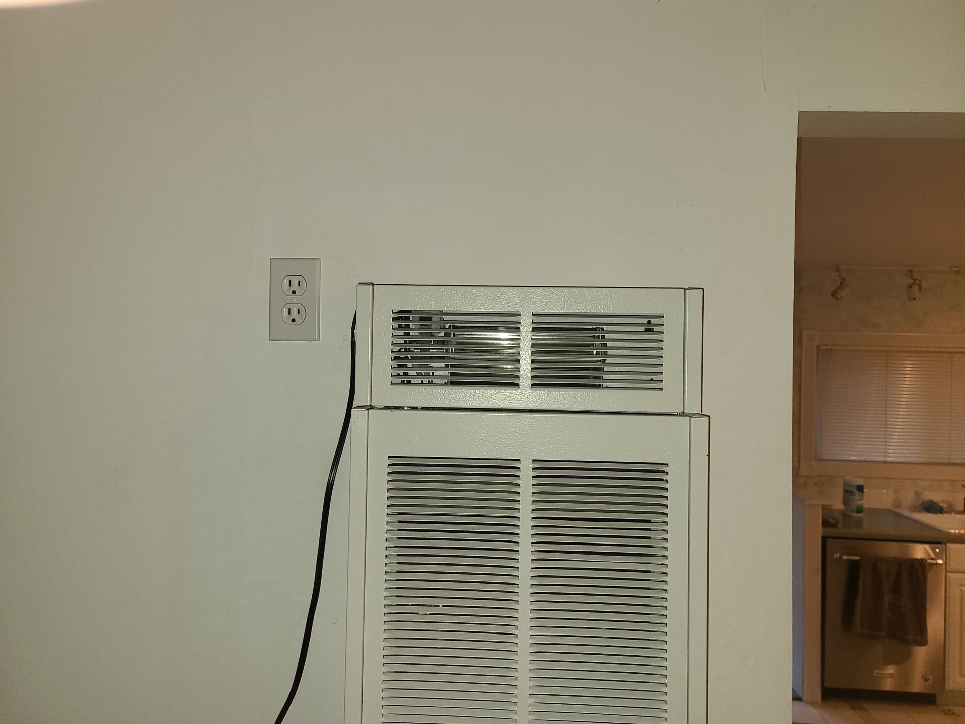 A white wall with a fan on top of it
