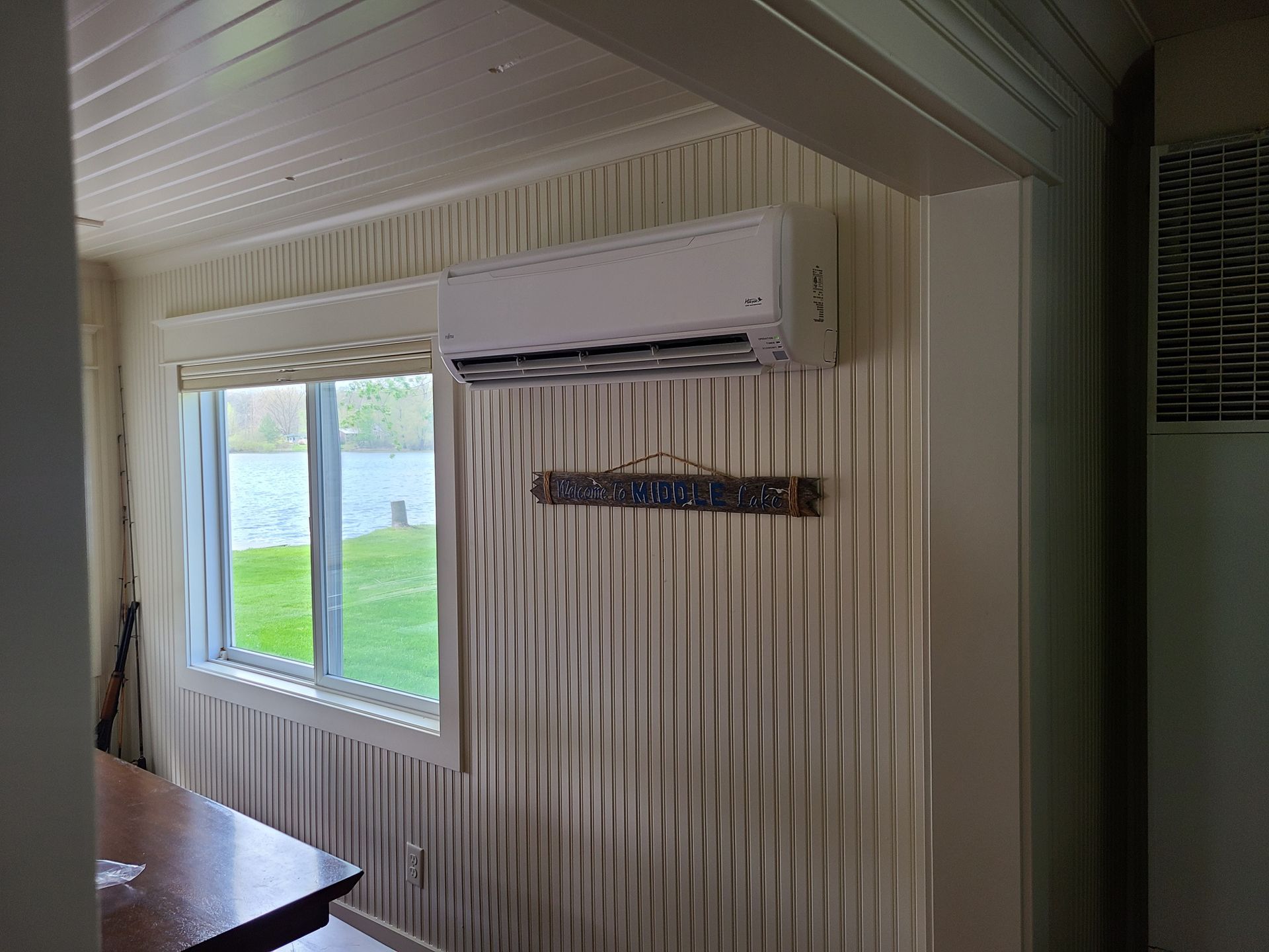 A room with a window and a wall mounted air conditioner.